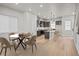 Open-concept kitchen and dining area with modern finishes, wood floors, and stylish lighting at 1727 W 166Th Ave, Broomfield, CO 80023