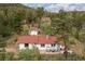 Secluded home features a red roof, inviting patio and surrounded by lush green trees, offering privacy and serene mountain views at 11827 Brook Rd, Golden, CO 80403