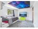 Cozy bedroom features unique ceiling tapestry and a large screen television at 11827 Brook Rd, Golden, CO 80403