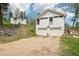 Exterior view of the property with a two-car garage, outbuilding, and lush greenery at 11827 Brook Rd, Golden, CO 80403