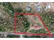 Aerial view of land outlined in red, showing property boundaries amongst dense trees and a house at 11827 Brook Rd, Golden, CO 80403