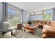 Bright living room featuring large windows offering scenic outdoor views, comfortable seating, and a stylish rug over wood floors at 11827 Brook Rd, Golden, CO 80403