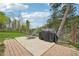 Outdoor patio space featuring a grill and a lounge chair surrounded by lush trees at 11827 Brook Rd, Golden, CO 80403