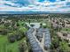 Stunning aerial view showcases the community's serene lake, lush greenery, and mountain backdrop at 2951 W Riverwalk Cir # N, Littleton, CO 80123