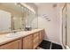 Bright bathroom featuring a double vanity, framed mirror, and glass-enclosed shower at 2951 W Riverwalk Cir # N, Littleton, CO 80123