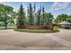 Riverwalk community entrance sign surrounded by flags and mature trees at 2951 W Riverwalk Cir # N, Littleton, CO 80123