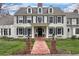 Elegant two-story home featuring classic architectural details, a brick walkway, and manicured lawn at 4682 S Franklin St, Englewood, CO 80113