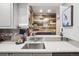 Kitchen sink view with stainless steel backsplash and wooden paneling leading to the dining area at 645 S Park Ave # 302, Breckenridge, CO 80424