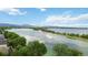 Picturesque view of a calm lake surrounded by lush greenery and distant mountains at 6296 W Prentice Ave, Littleton, CO 80123