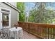 Cozy back deck featuring a table, chairs, and a picturesque view of the surrounding trees at 6296 W Prentice Ave, Littleton, CO 80123