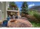 Spacious backyard has mature trees, a stone patio, a built in firepit and an outdoor kitchen at 6296 W Prentice Ave, Littleton, CO 80123