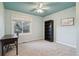 Inviting bedroom with a blue ceiling, large window, carpeted floors, and ample space for a desk and bookshelf at 6296 W Prentice Ave, Littleton, CO 80123