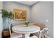 Cozy dining area features a round table, banquette seating, and a lovely garden view at 6296 W Prentice Ave, Littleton, CO 80123
