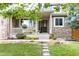 Charming front porch with stone accents, well manicured lawn, and walkway, inviting relaxation and curb appeal at 6296 W Prentice Ave, Littleton, CO 80123