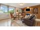 Comfortable living room featuring built-in shelving, fireplace, and large windows at 6296 W Prentice Ave, Littleton, CO 80123
