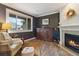 Cozy living room boasts a fireplace, decorative cabinet, and large window with natural light at 6296 W Prentice Ave, Littleton, CO 80123