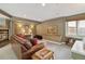 Finished basement living room with plush leather sofa, built in shelving, and decorative lighting at 6296 W Prentice Ave, Littleton, CO 80123
