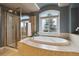 Luxurious main bathroom with separate shower, soaking tub, and a large arched window at 6296 W Prentice Ave, Littleton, CO 80123