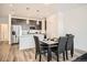 Dining area adjacent to kitchen with modern table, pendant lights, and stainless appliances at 370 Geneva St, Aurora, CO 80010