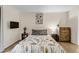 Comfortable bedroom featuring neutral decor, wooden furniture, and a mounted television at 9797 E Peakview Ave # C1, Englewood, CO 80111
