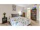 Bedroom with wood-style flooring, decorated with a painting and a bookcase next to bathroom access at 9797 E Peakview Ave # C1, Englewood, CO 80111