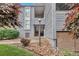 Gray two-story condominium with stone accents and a walkway leading to the entrance and mature landscaping at 9797 E Peakview Ave # C1, Englewood, CO 80111