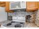Updated kitchen features granite counters, tiled backsplash, stainless appliances and wooden cabinets at 9797 E Peakview Ave # C1, Englewood, CO 80111