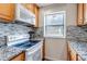 Updated kitchen features granite counters, tiled backsplash, wooden cabinets, and stainless appliances at 9797 E Peakview Ave # C1, Englewood, CO 80111