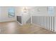 Second floor hallway with dark metal and white banister, hardwood floors and natural light at 42964 Colonial Trl, Elizabeth, CO 80107