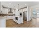 Modern kitchen with white cabinets, stainless steel appliances, herringbone backsplash, and island with built-in microwave at 42964 Colonial Trl, Elizabeth, CO 80107