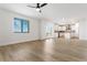 Open living space featuring hardwood floors, a ceiling fan, a large window, and an open floor plan at 42964 Colonial Trl, Elizabeth, CO 80107