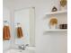 Well lit bathroom with floating shelves, neutral color palette, and a mirror at 16568 W 92Nd Pl, Arvada, CO 80007