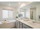 Well-lit bathroom featuring double sinks, soaking tub, and contemporary fixtures in a modern design at 16568 W 92Nd Pl, Arvada, CO 80007