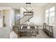 Dining area featuring a long wooden table, modern light fixture, and staircase access at 16568 W 92Nd Pl, Arvada, CO 80007