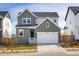 Charming two-story home with gray siding, a white garage door, and well-maintained landscaping at 16568 W 92Nd Pl, Arvada, CO 80007