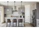 Modern kitchen featuring gray cabinetry, stainless steel appliances, and a spacious center island with seating at 16568 W 92Nd Pl, Arvada, CO 80007