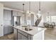 Modern kitchen features stainless steel appliances, island with sink, and gray cabinets with light countertops at 16568 W 92Nd Pl, Arvada, CO 80007