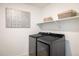 Laundry room with modern washer and dryer, stylish wall art, and shelving for storage at 16568 W 92Nd Pl, Arvada, CO 80007