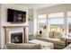 Cozy living room with a fireplace, large windows, and comfortable seating at 16568 W 92Nd Pl, Arvada, CO 80007