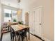 Bright dining area features stylish pendant lighting over a wood table, next to a bright window at 1246 Xavier St, Denver, CO 80204