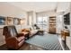 Bright living room with modern furnishings, hardwood floors and oversized window showcasing neighborhood views at 1246 Xavier St, Denver, CO 80204