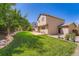 Spacious backyard featuring lawn area with rock border, home and patio at 5534 S Wenatchee St, Aurora, CO 80015