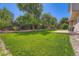 Lush backyard featuring a large green lawn, patio area, and mature landscaping at 5534 S Wenatchee St, Aurora, CO 80015