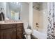 Bathroom with a dark vanity, granite countertop, tile flooring, toilet, and a tub/shower combo at 5534 S Wenatchee St, Aurora, CO 80015