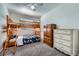 Bedroom features a bunk bed, wooden dressers, carpet, and bright natural lighting at 5534 S Wenatchee St, Aurora, CO 80015
