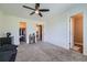 Bedroom with neutral walls, carpet, ceiling fan, closet, and doorway to an ensuite bathroom at 5534 S Wenatchee St, Aurora, CO 80015