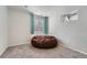 Cozy bedroom featuring a brown beanbag chair, window with curtains, and neutral decor at 5534 S Wenatchee St, Aurora, CO 80015
