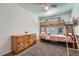Bedroom features a bunk bed, wooden dresser, carpet, and bright natural lighting at 5534 S Wenatchee St, Aurora, CO 80015
