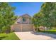 Charming two-story home features a three-car garage, mature trees, and a well-manicured lawn at 5534 S Wenatchee St, Aurora, CO 80015