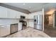 Bright kitchen with stainless steel appliances, white cabinetry, tile flooring, and plenty of counter space at 5534 S Wenatchee St, Aurora, CO 80015
